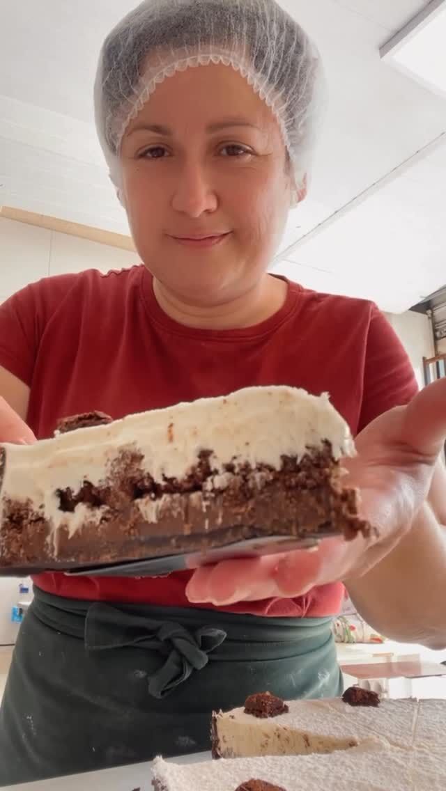 Confeiteira segurando uma torta recém-montada